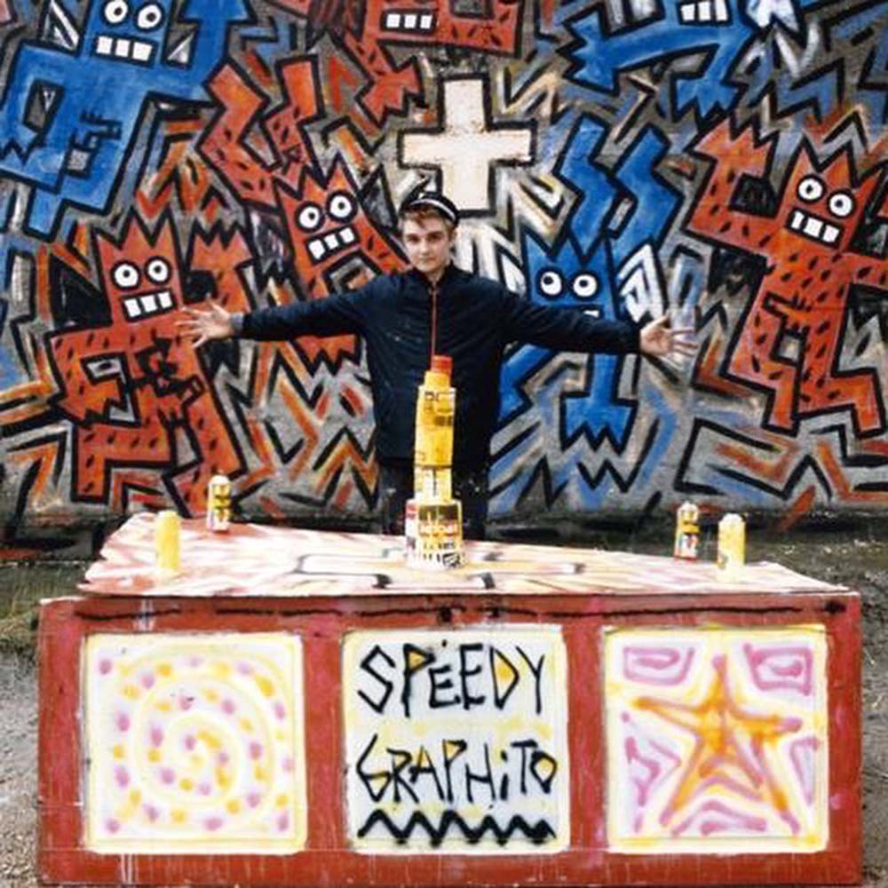 Speedy Graphito Photo de Speedy Graphito dans les années 80 devant une de ses fresques, street art Paris