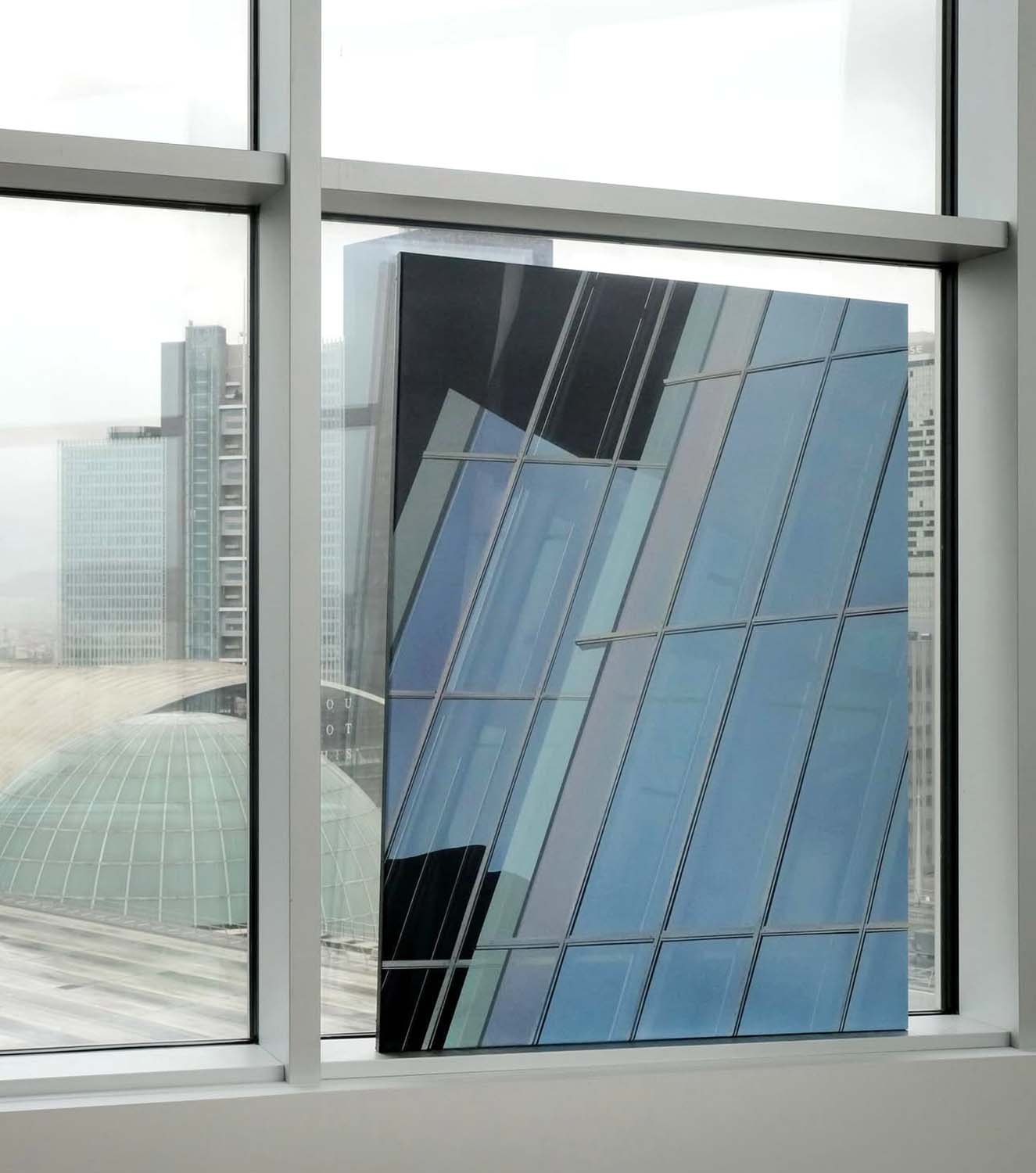 Oeuvre d'Etienne Gayard représentant une façade vitrée avec des reflets de lumières, caractéristique de l'artiste. À voir en galerie d'art